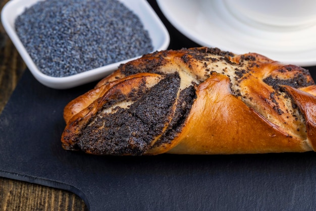 Fresh bun with poppy seed filling on the table sweet flour dessert with sweet filling with poppy seeds