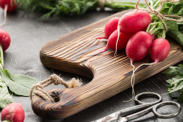 Fresh bunch of radish on a cutting board.