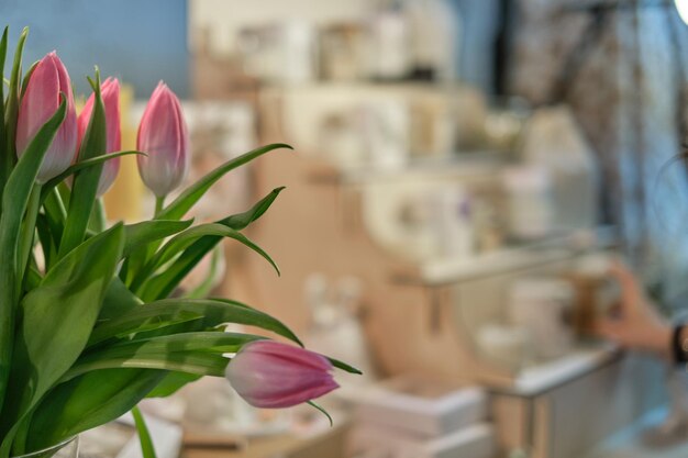 Fresh bunch of tulips is beautifully contrasted against the outoffocus backdrop of a charming handcrafted goods stall at a springthemed marketplace