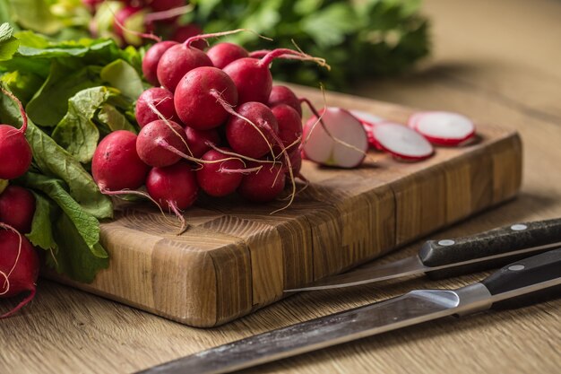 Fresh bundles of radish laid on a kitchen table.