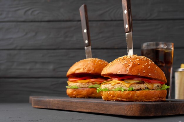 Fresh burger and fries on black wooden , front view