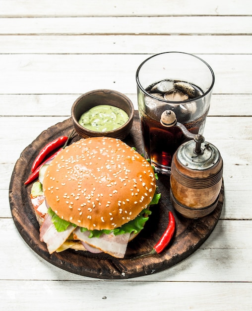 Fresh burger with cola on a wooden board