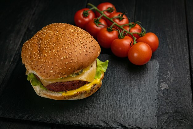 Fresh burger with vegan meat and vegetables, sprinkled with sesame seeds