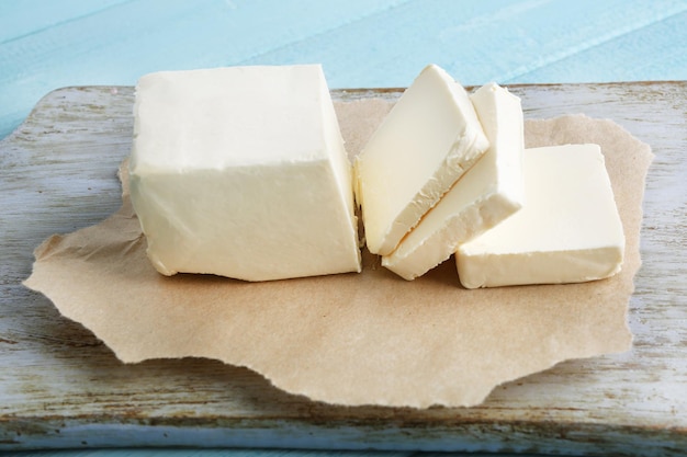 Fresh butter on cutting board on color wooden background