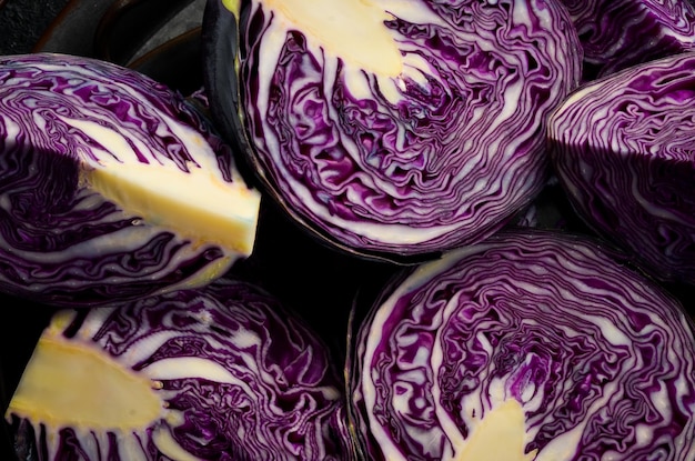 Fresh cabbage fresh sliced purple cabbage on a black stone\
background