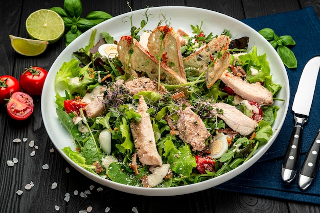 Fresh caesar salad in white plate on dark wooden table Top view Serving food in a restaurant Healthy food concept Photo for the menu