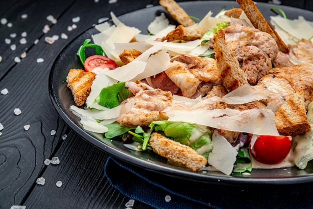 Insalata caesar fresca in piatto bianco su tavolo di legno scuro vista dall'alto