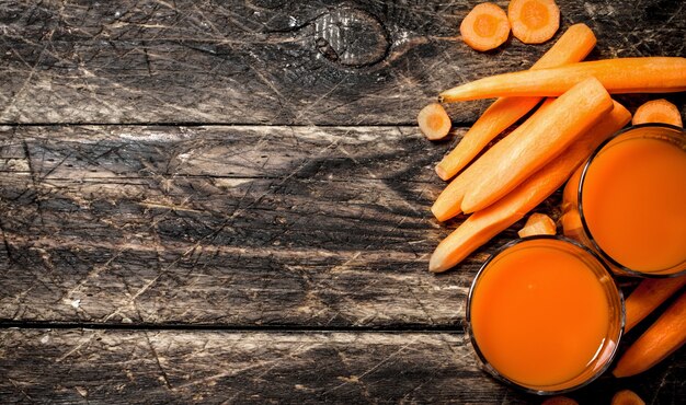 Fresh carrot juice on old wooden table.