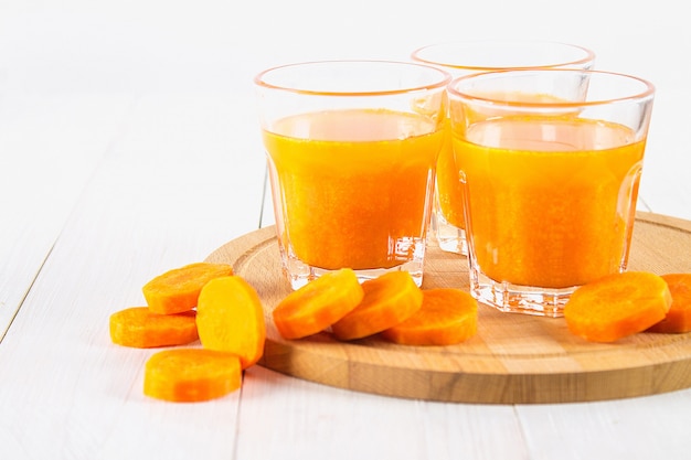 Fresh carrot juice on a wooden background