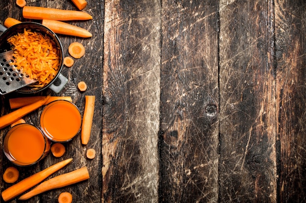 Fresh carrot juice on wooden table