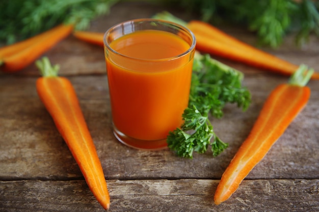 Foto succo di carota fresco sulla tavola di legno