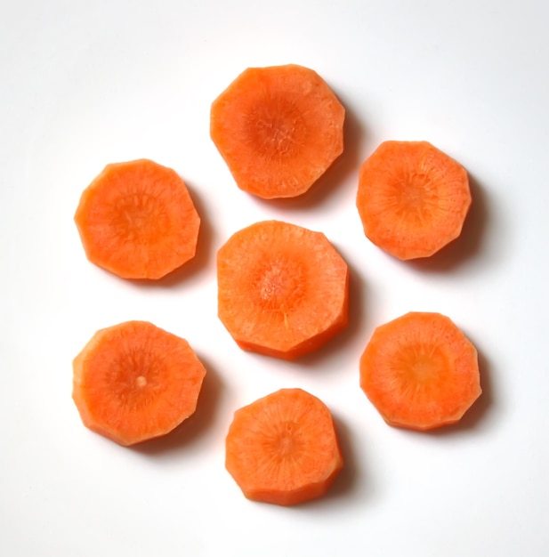 Fresh carrot round orange slices on white background close up.