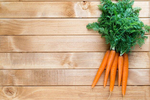 Fresh carrot vegetable with leaves on the wooden