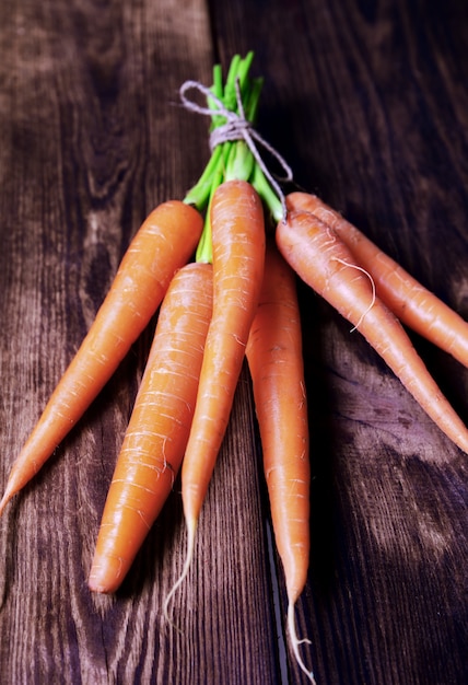 Fresh carrots on a brown wooden background