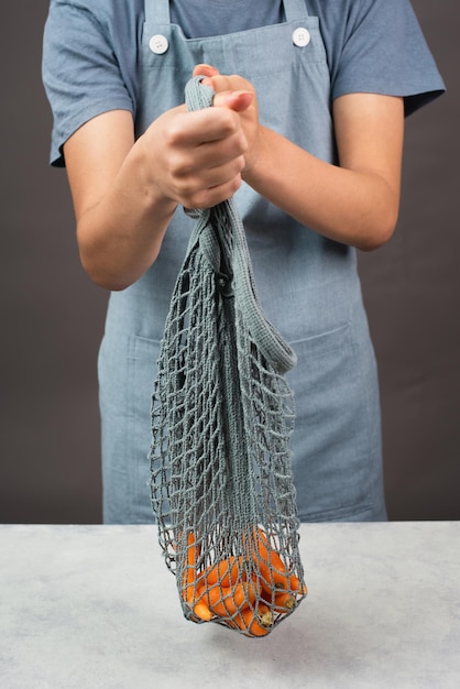 Fresh carrots in a reusable grocery mesh bag vegetables from the market healthy food zero waste