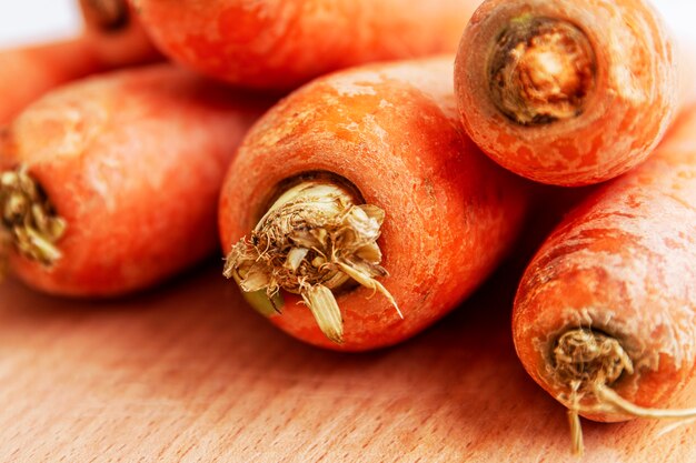 Fresh carrots on a wooden board. Healthy nutrition and vitamins. Close-up.