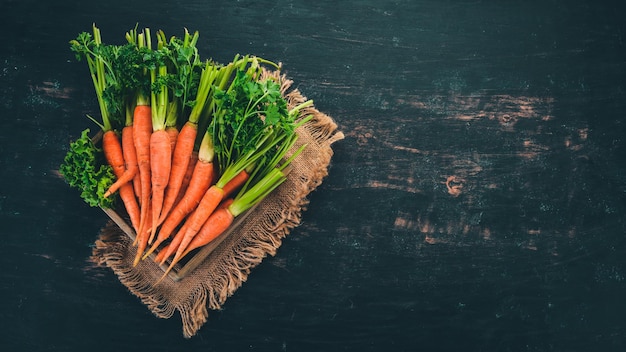 Fresh carrots in a wooden box On a wooden background Top view Copy space