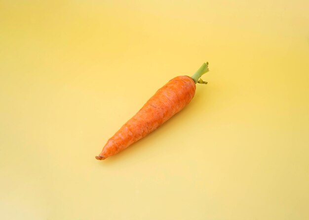 Fresh carrots on a yellow background healthy eating concept