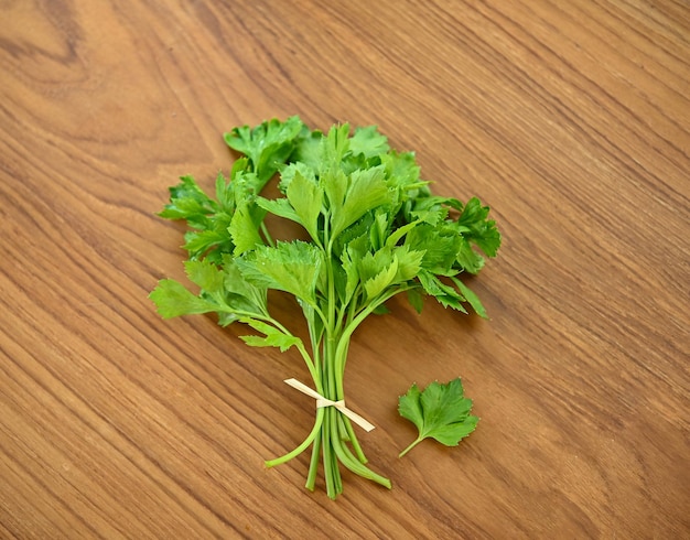 Fresh celery leaves and stalks on wood background preparation healthy eating lifestyle top view photo