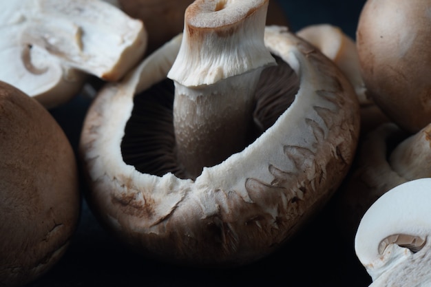 Fresh champignon mushrooms on black background