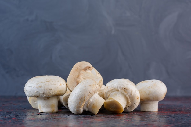 Fresh champignon mushrooms isolated on a dark surface