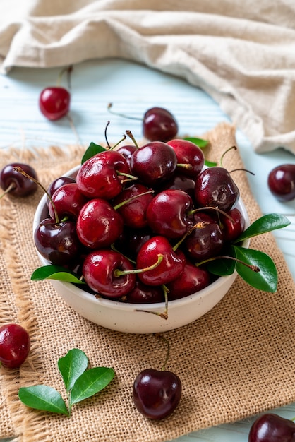 Fresh cherries in bowl  on wood background