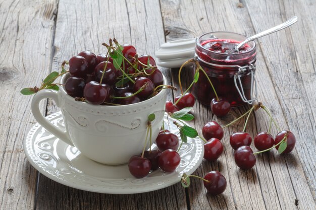 Fresh cherries in cup on table