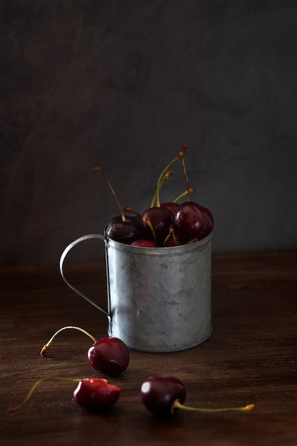 Fresh cherries in a vintage metal mug