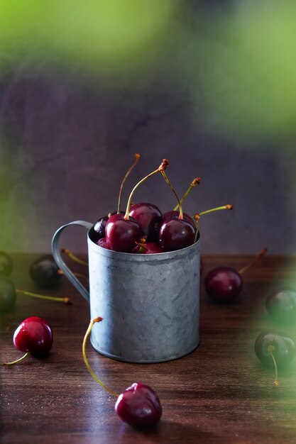 Fresh cherries in a vintage metal mug