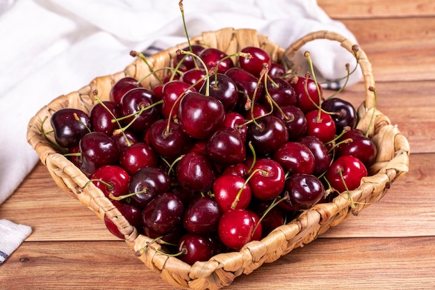 Fresh cherry Ripe cherries in a basket on wood background Bulk cherries close up