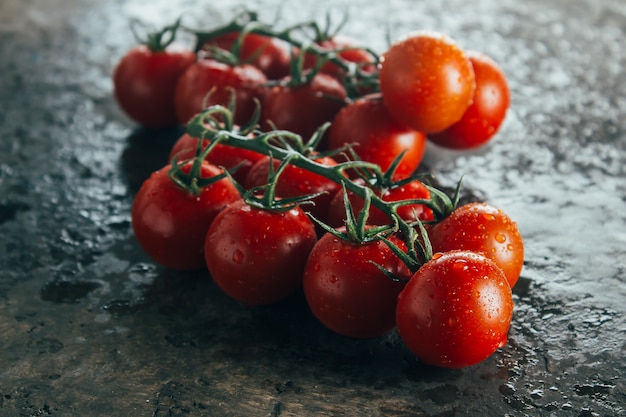 Fresh cherry tomatoes on a dark brown backround