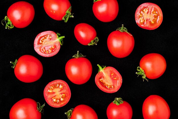 Fresh cherry tomatoes isolated on a black whole and cut in half.