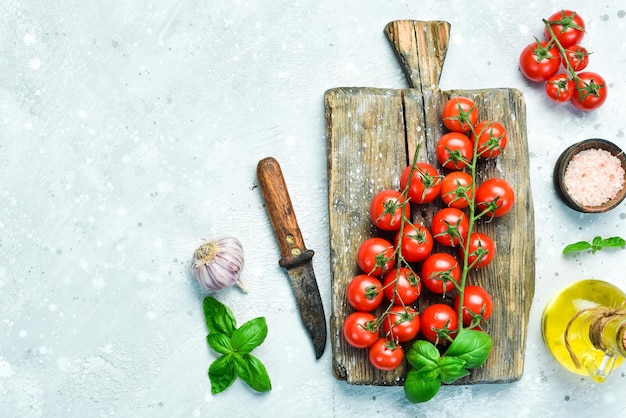 Fresh cherry tomatoes on a sprig On a blackboard on a gray stone background Top view Free space for text