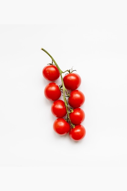 Fresh cherry tomatoes on the vine on white background. Top view.