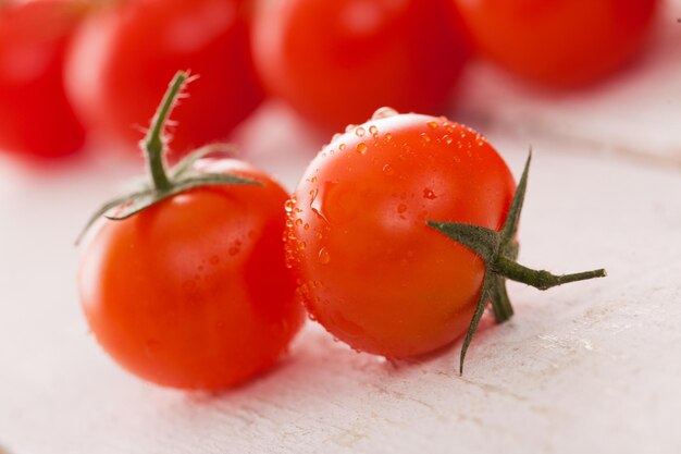 Fresh cherry tomatoes on a white surface