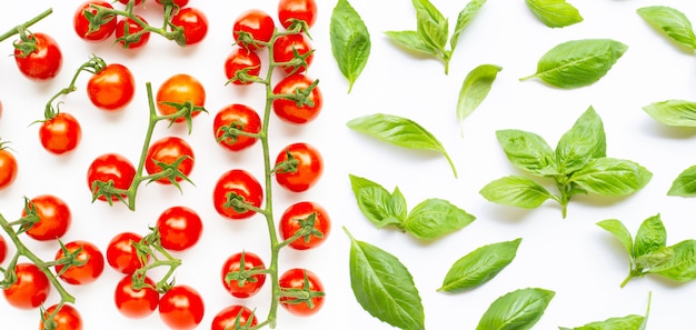 Photo fresh  cherry tomatoes with basil leaves on white background.