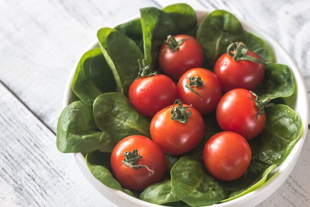 Fresh cherry tomatoes with spinach leaves