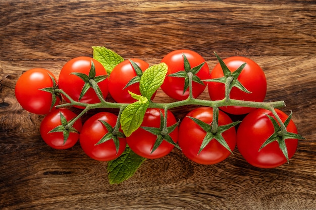 Fresh cherry tomatoes on a wooden background with spices.