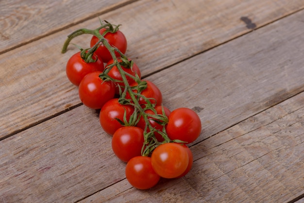 Fresh cherry tomatoes on wooden background