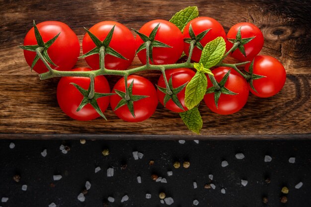 Fresh cherry tomatoes on a wooden with spices.