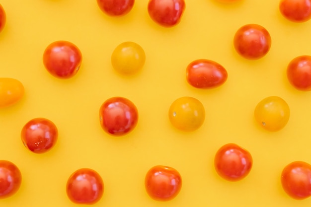 Fresh cherry tomatoes on yellow background