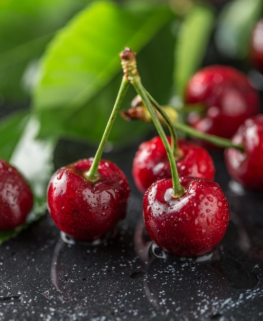 Fresh cherry with water drops on dark table.