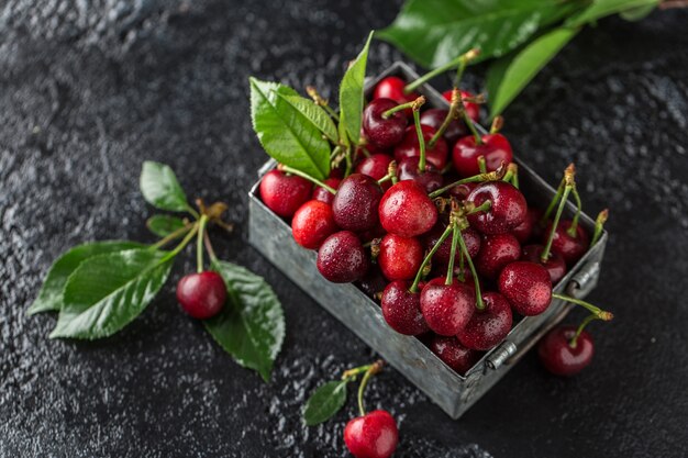 Fresh cherry with water drops on dark table.