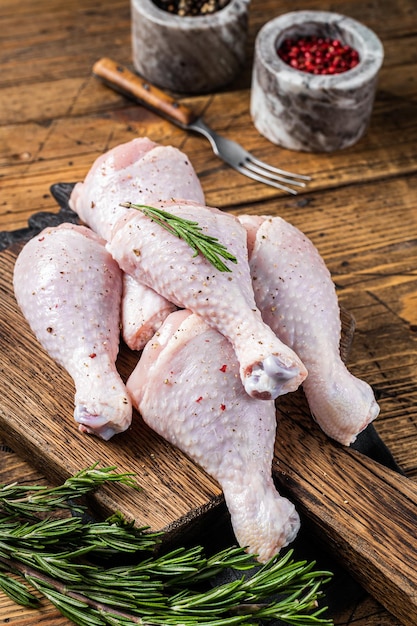 Fresh Chicken drumsticks legs with skin raw poultry meat Wooden background Top view