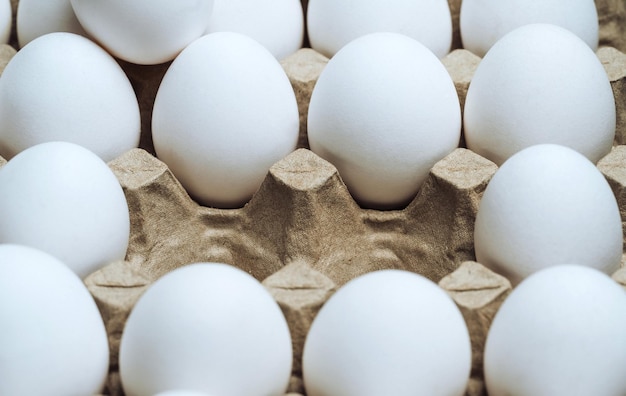 Fresh chicken eggs are fresh in a cardboard package made of recycled waste paper Spare place in carton bow with eggs Closeup