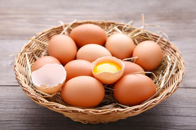 Fresh Chicken eggs in basket on grey wooden background