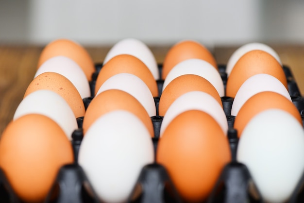 Fresh chicken eggs and duck eggs in box on wooden table