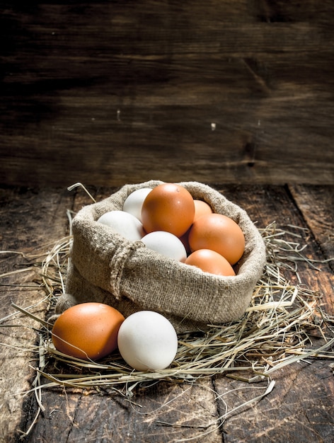 Fresh chicken eggs in an old bag. On a wooden background.