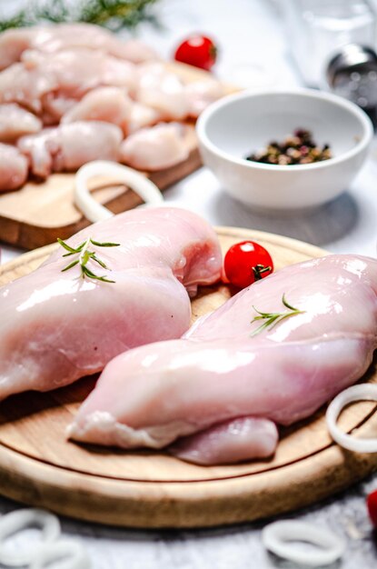 Foto filetto di pollo fresco con spezie su un tavolo bianco