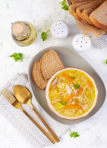 Свежий куриный суп с овощами и звездными макаронами в миске с морковью и петрушкой